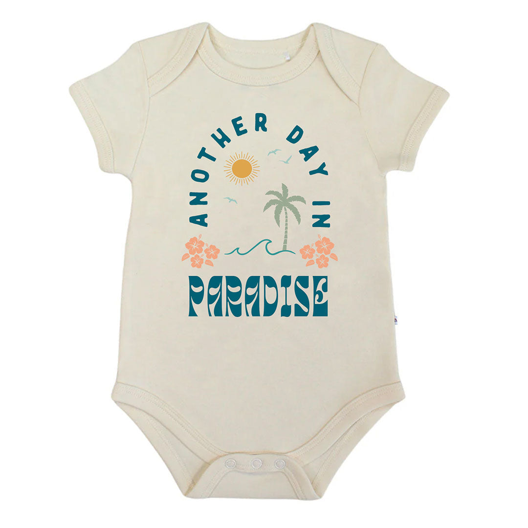 Baby onesie with 'Another Day in Paradise' text and graphics on a white background