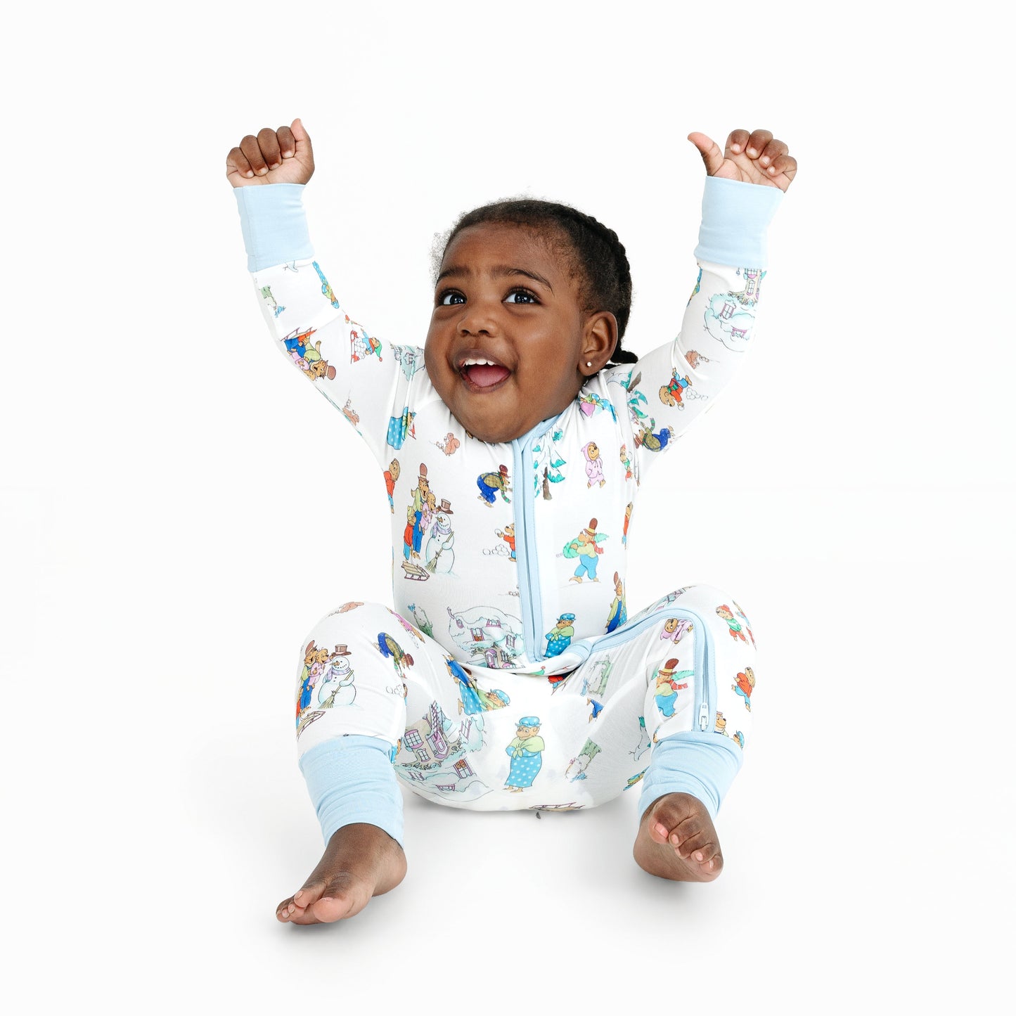 Child wearing a colorful onesie with cartoon characters on a white background