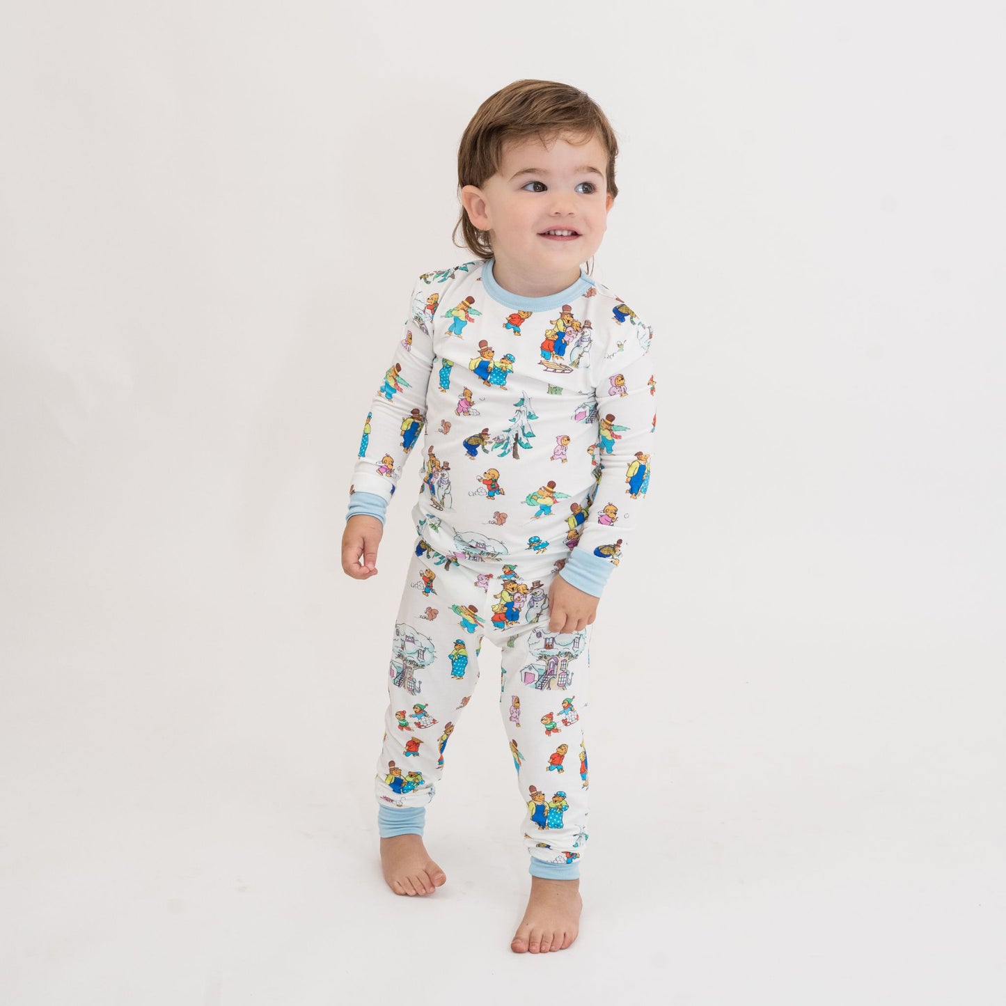 Child wearing a patterned onesie on a plain background