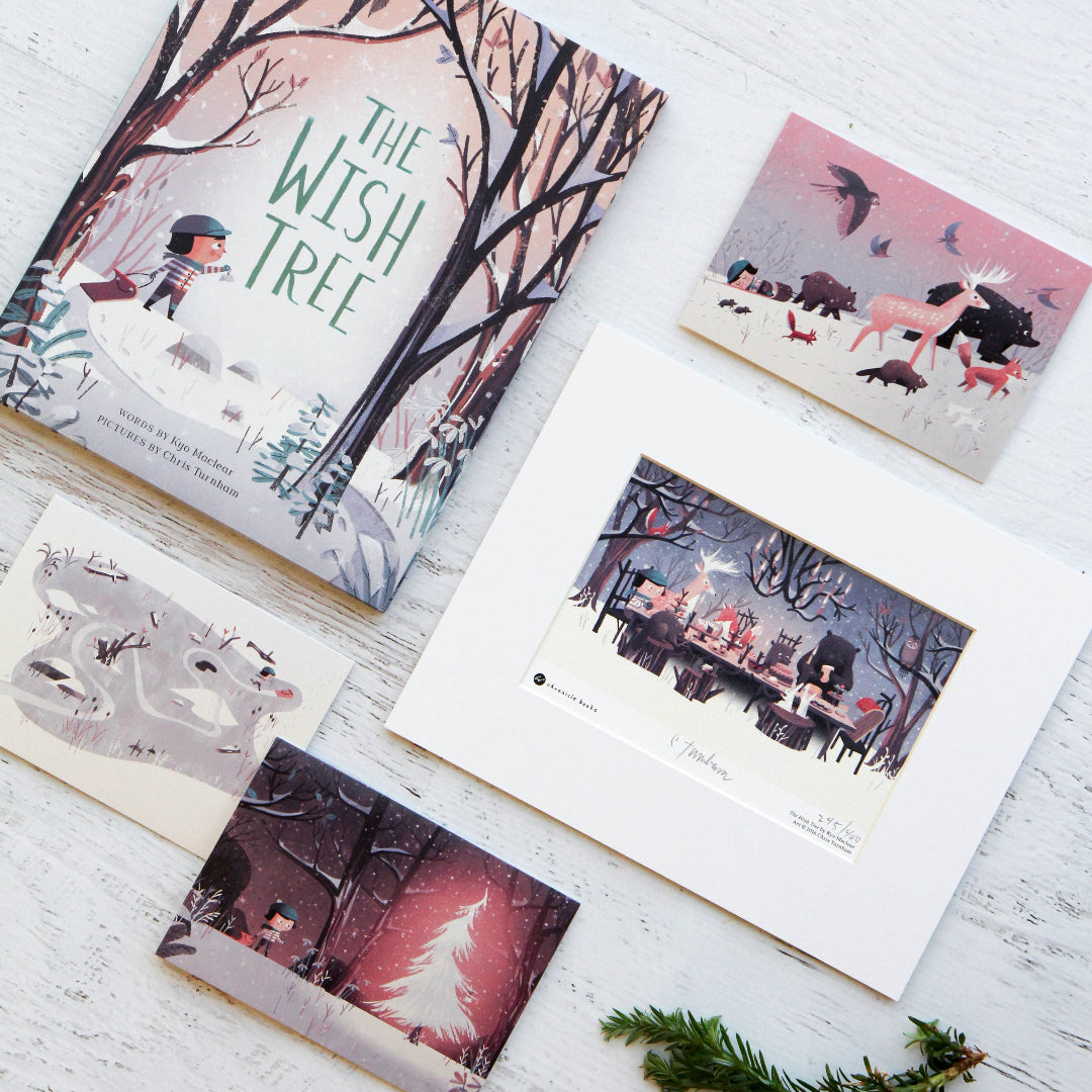 Children's book titled 'The Wish Tree' on a white surface with other books and decorative elements.