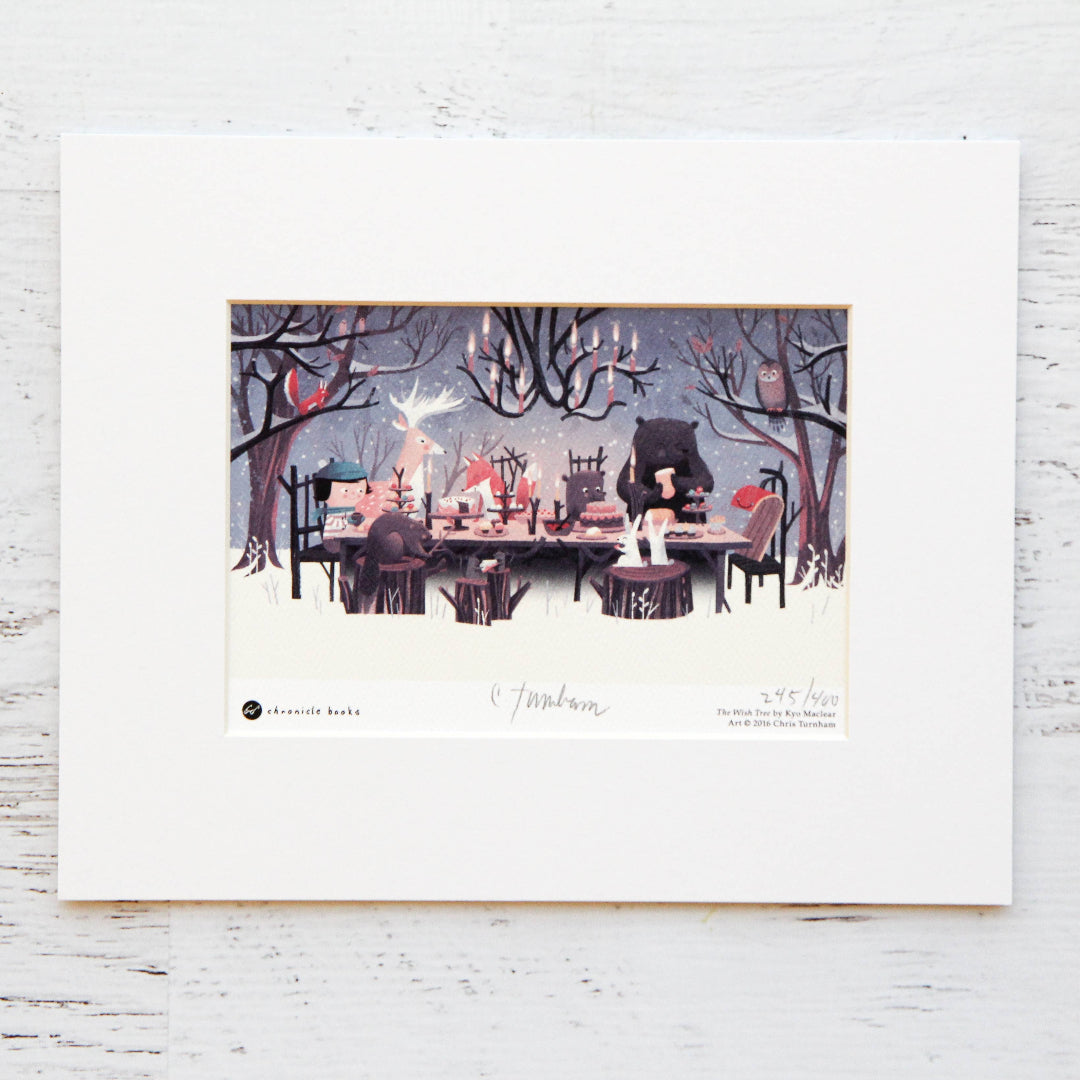 Framed artwork of a fantasy scene with characters around a table on a white wooden surface.