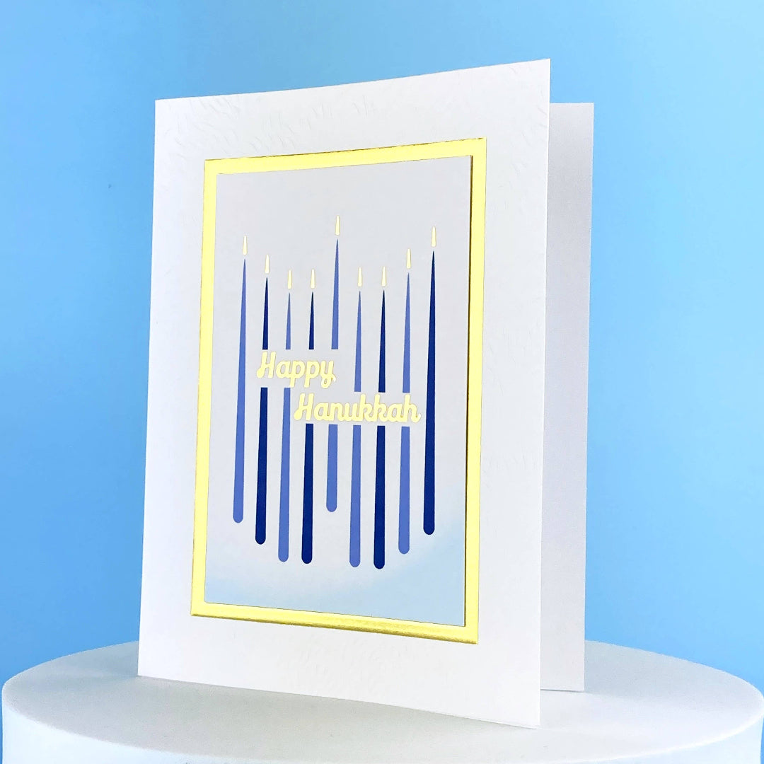 greeting card that has 9 blue candles on it and says Happy Hanukkah