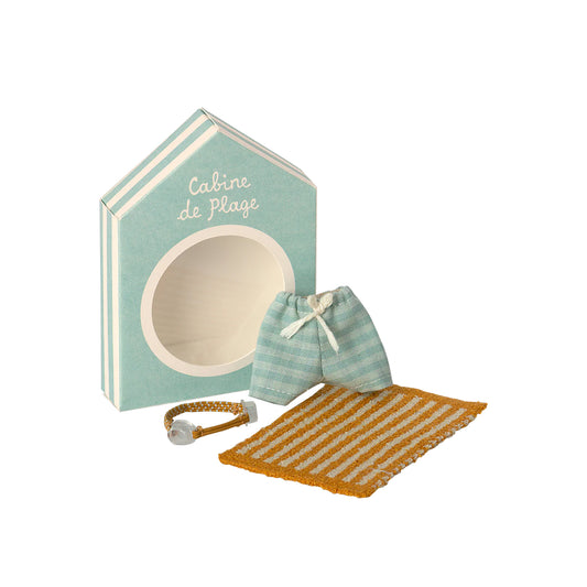 Set with a beach hut, striped shorts, and a bracelet on a white background