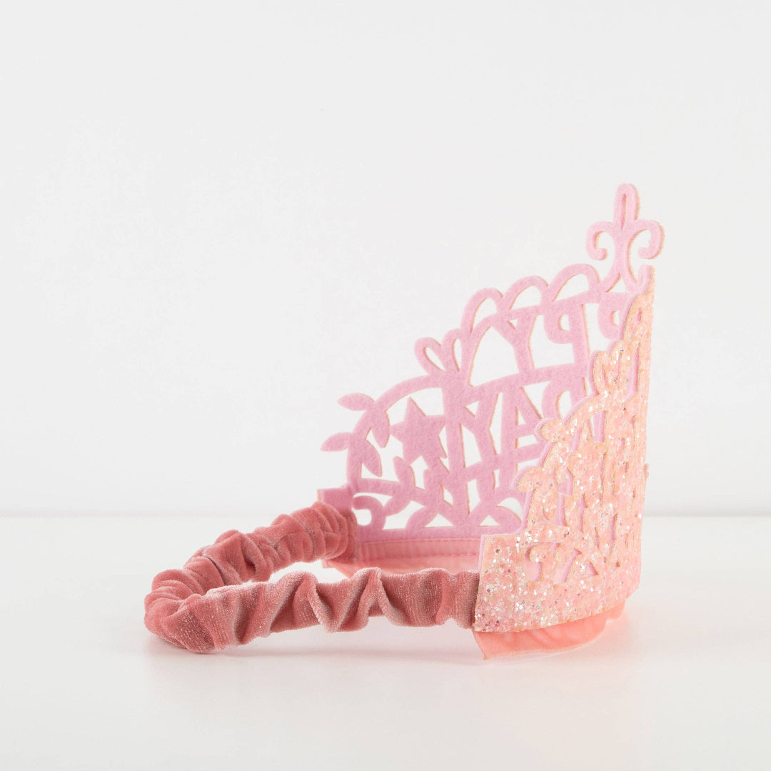 Pink headband with decorative lace design on a white background
