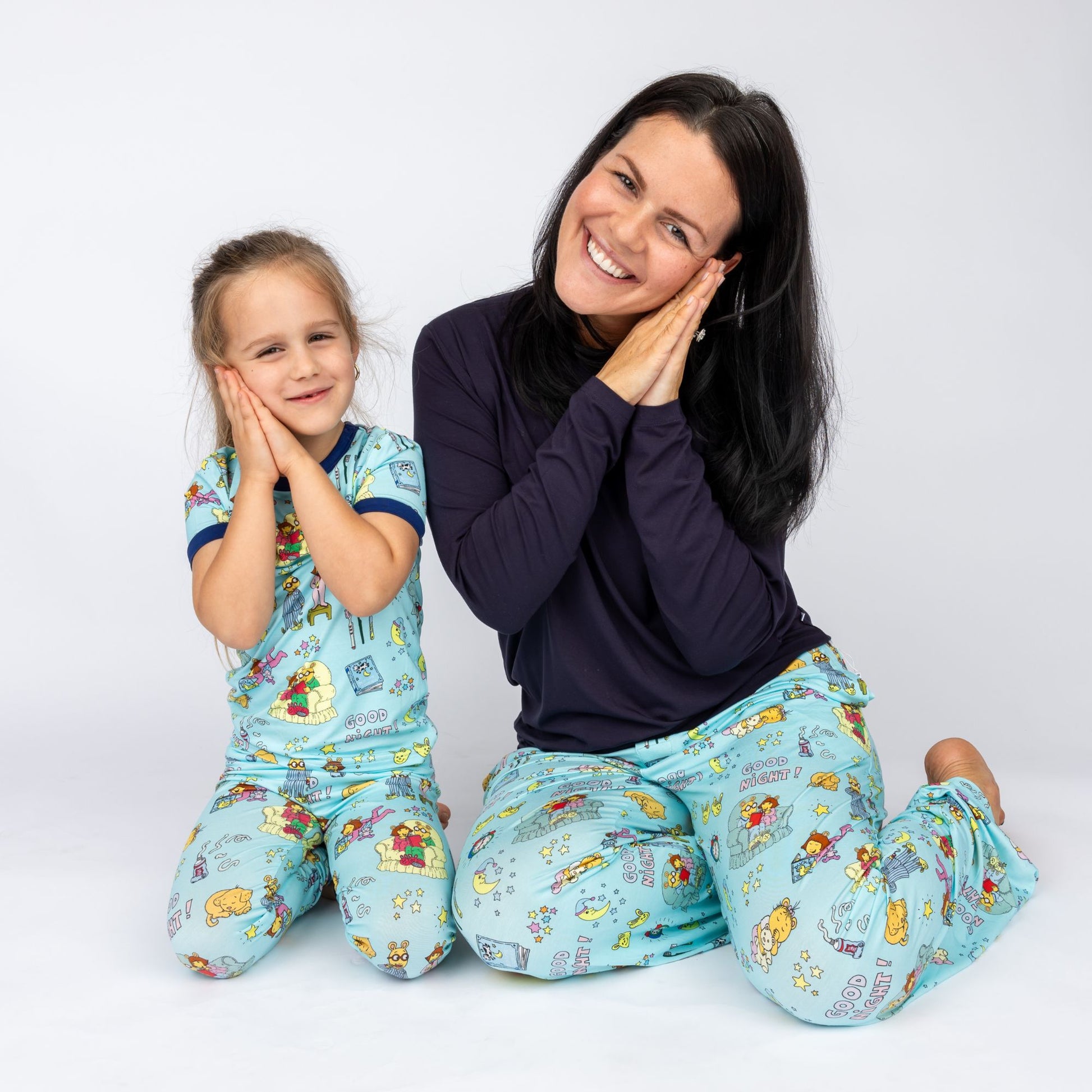 Woman and child wearing Good Night Arthur™ matching pajamas on a white background