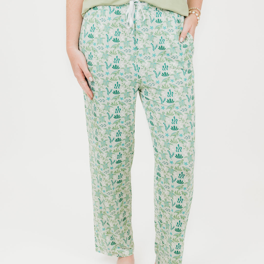Woman wearing our Relaxed Long Pants from our Save the Sea Turtle Collection. Featuring\a serene ocean-inspired print with sea turtles and marine life, these ultra-soft bamboo pieces are breathable, moisture-wicking, and eco-friendly. Perfect for lounging or sleeping in sustainable style.