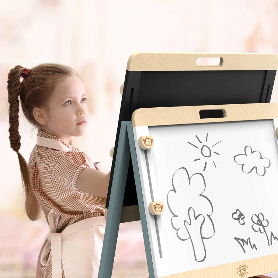 a little girl drawing on a wooden art easel