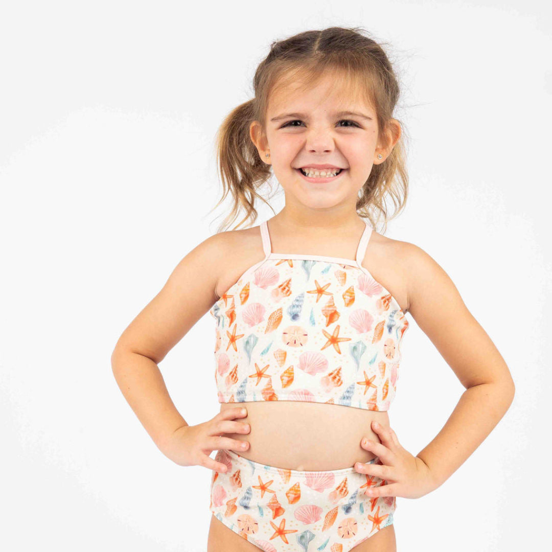 Close of the top for our 2 piece Sandy Seashell swimwear. The print reflects seashells is different peach, pink and blue colors. The trim on the top is light pink.