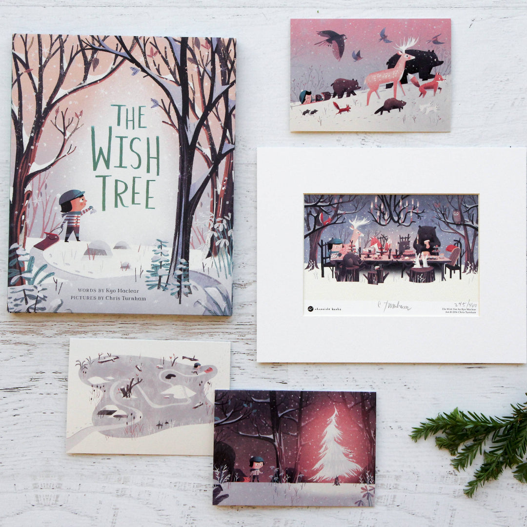 Collection of illustrated cards on a white wooden surface with a Christmas tree branch.