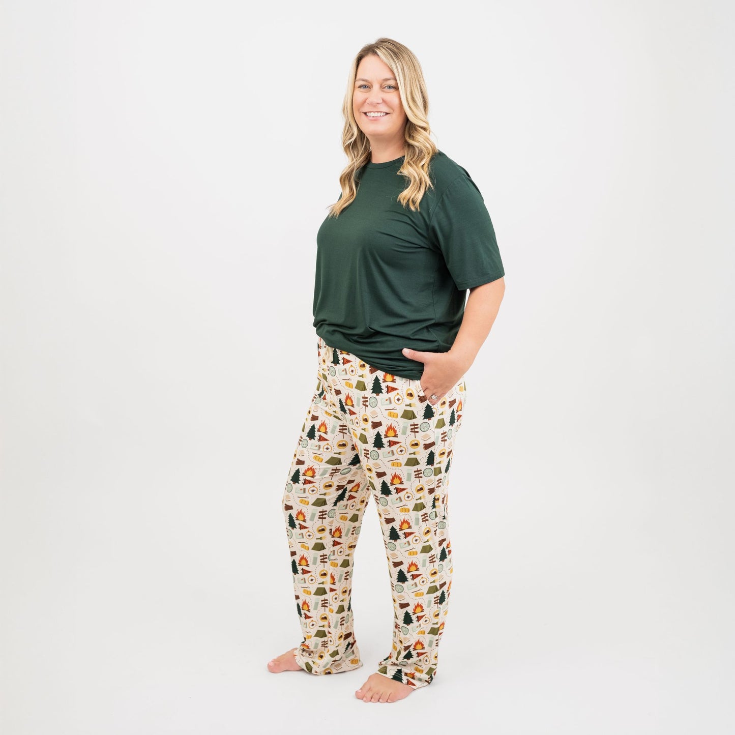 Woman wearing a green top and Camp Emerson bamboo relaxed pajama pants on a white background