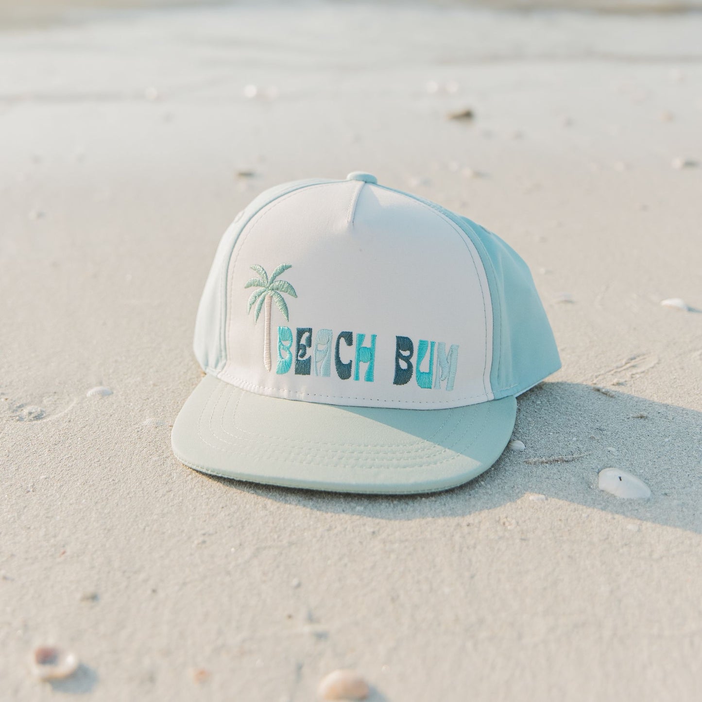 Beach bum cap with palm tree design on a sandy background
