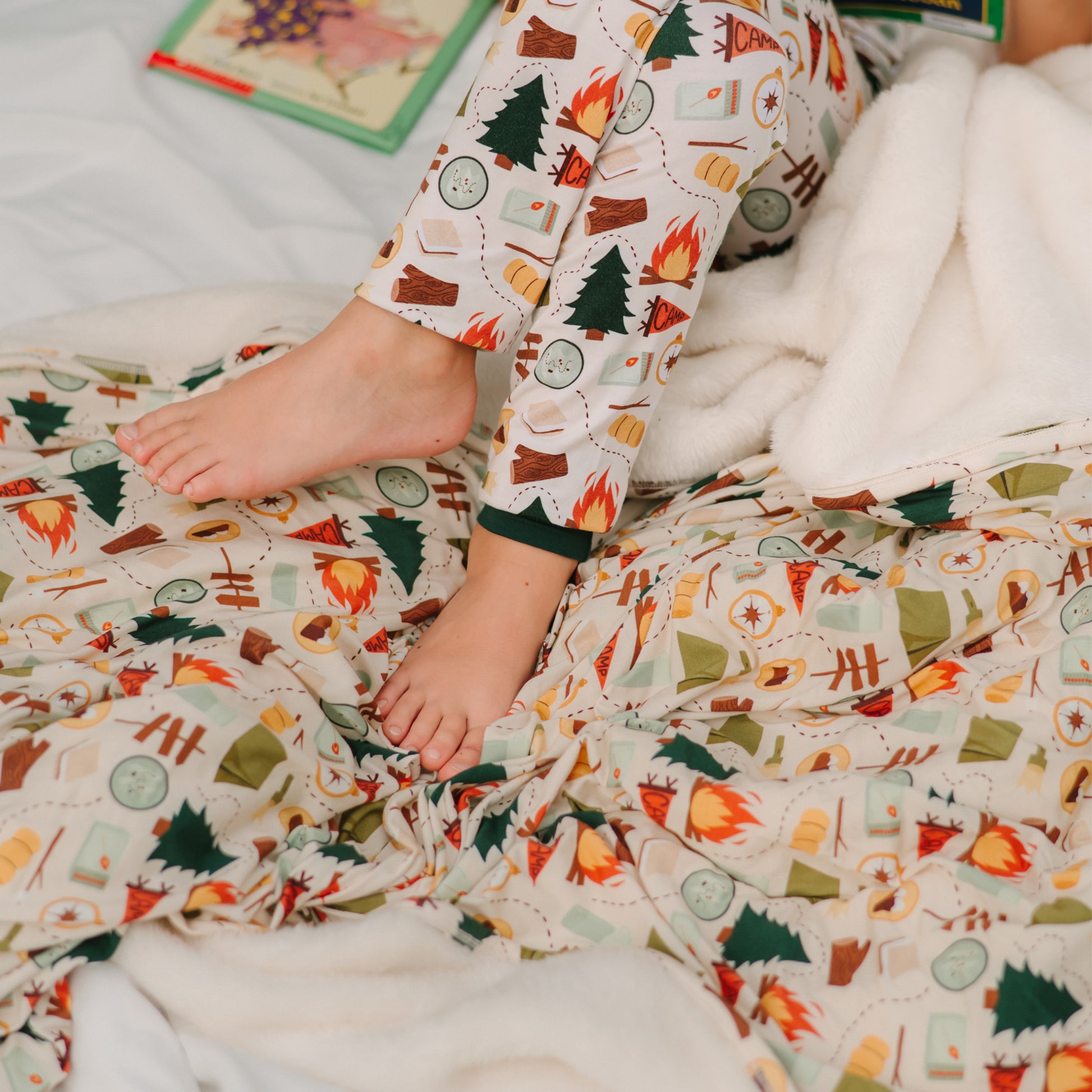 Close-up of feet resting on Camp Emerson bamboo and fleece camping blanket.