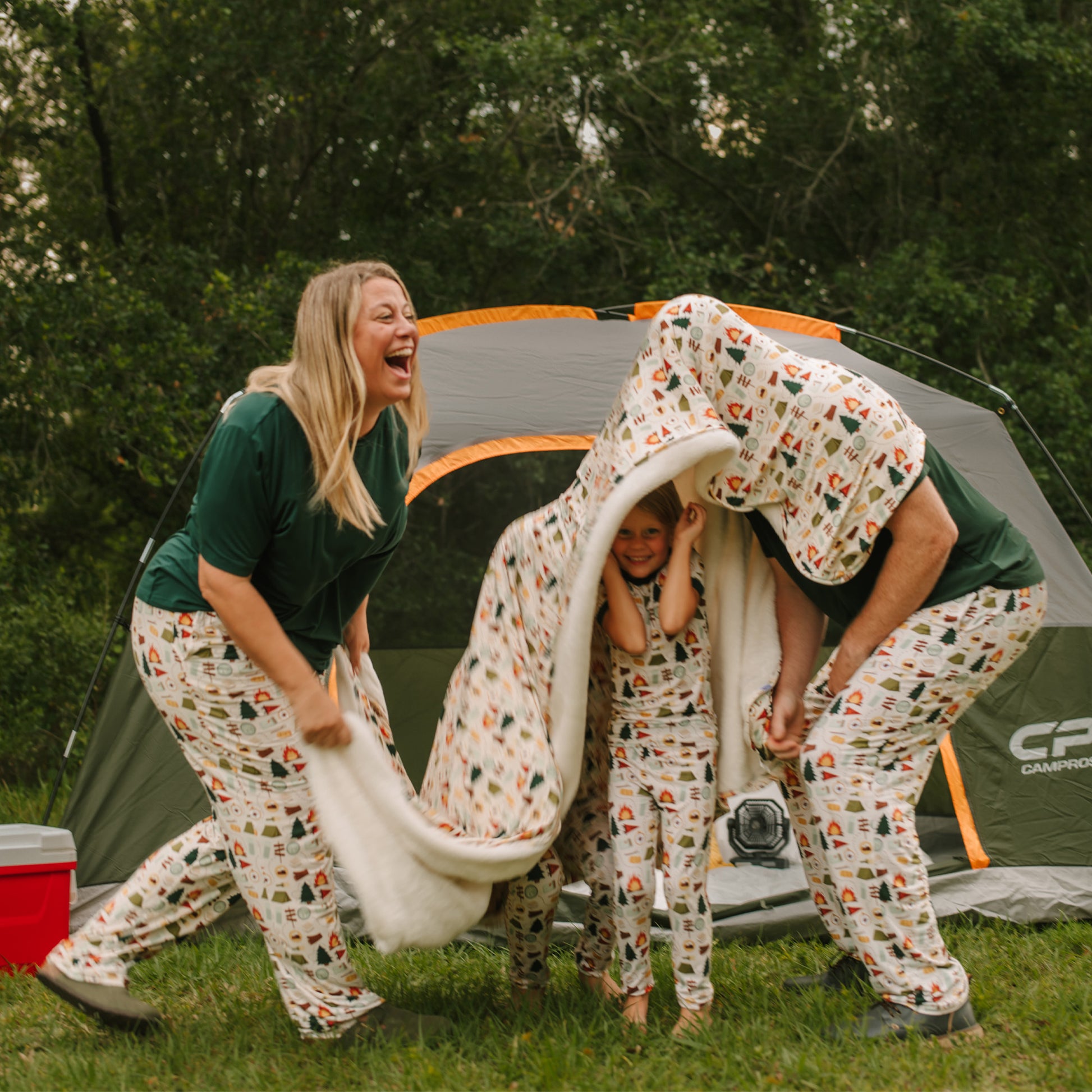 Couple playfully holding a blanket outside a tent while wearing Camp Emerson bamboo lounge pants.