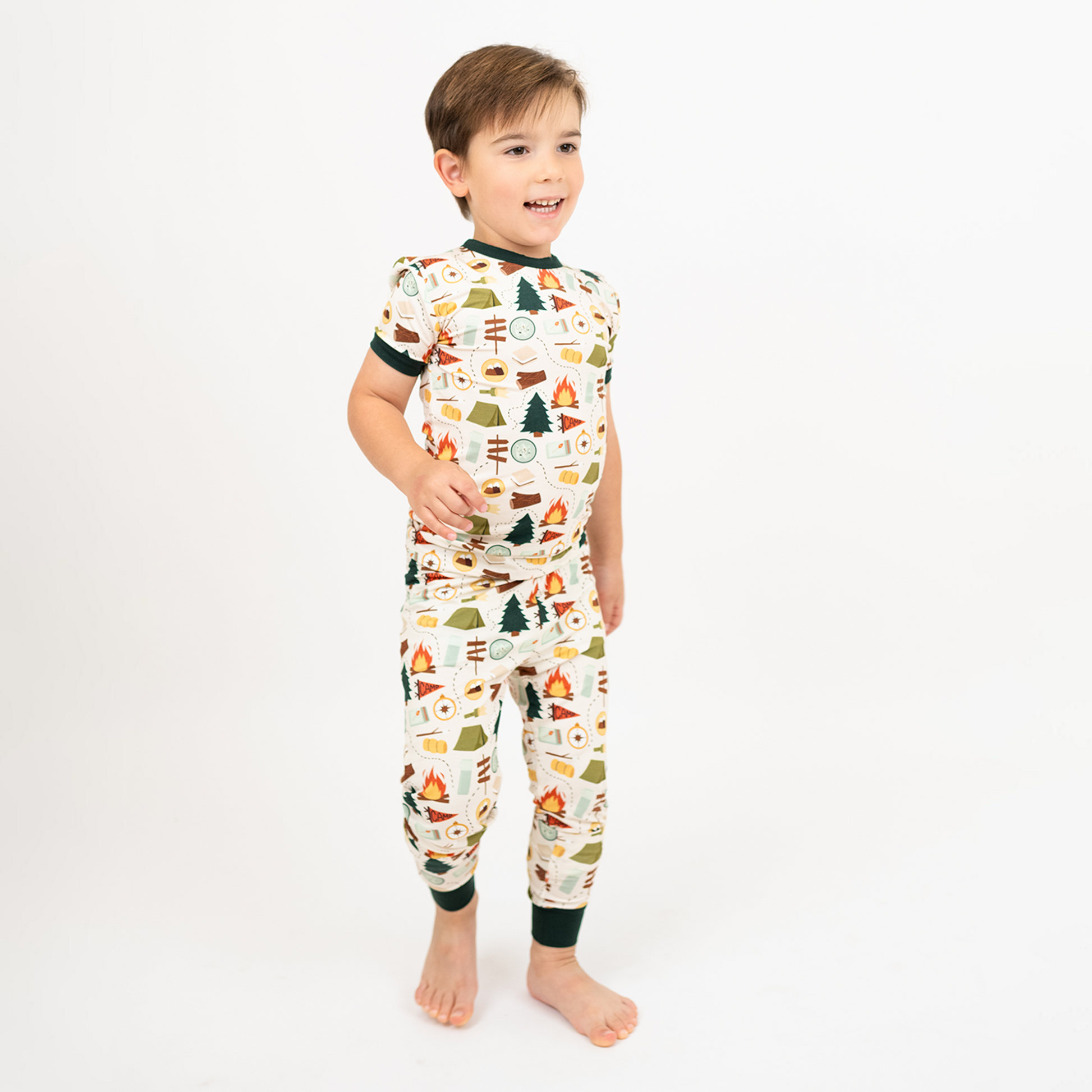 Boy standing in camping print bamboo pajama set, short sleeve top and pants.