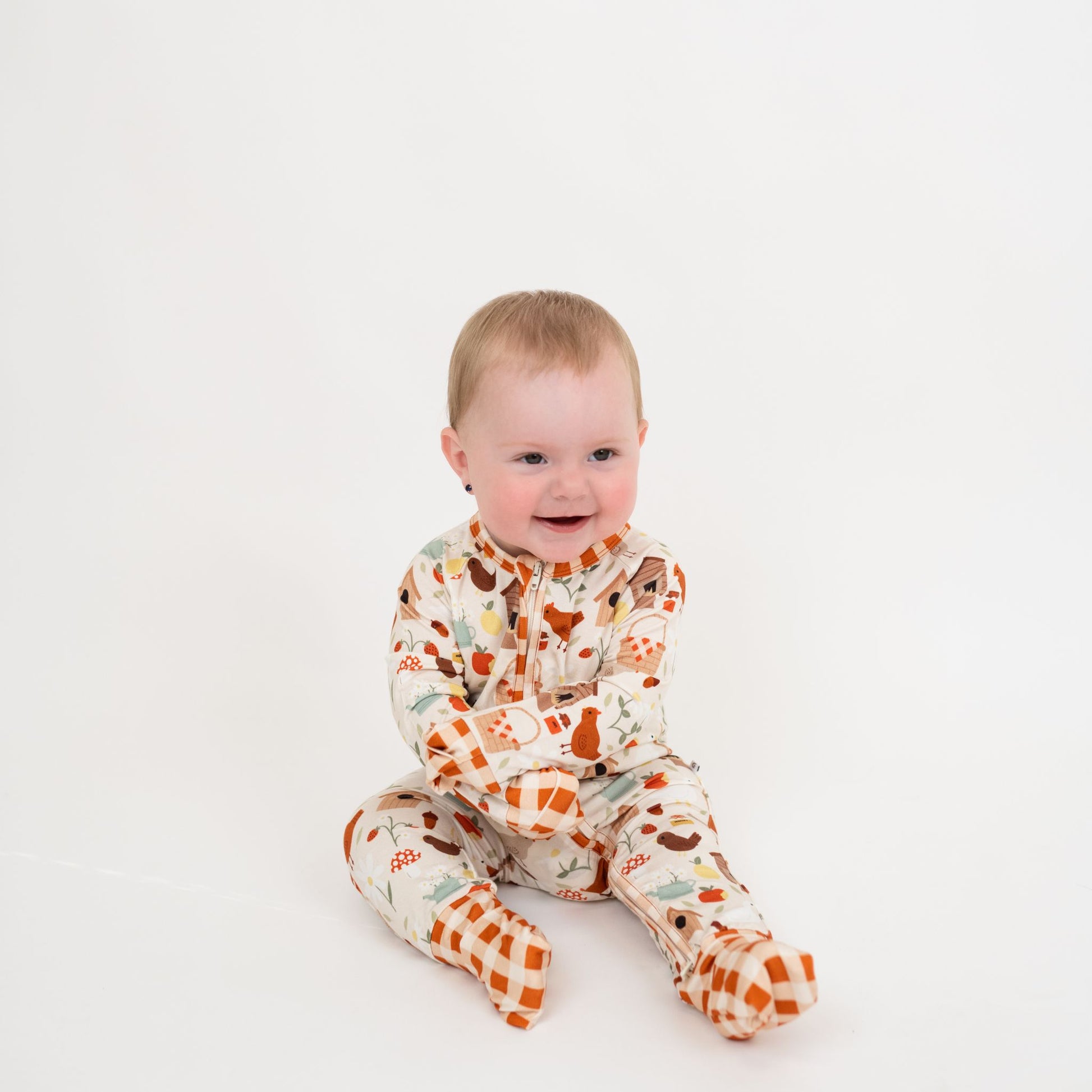 Smiling baby in cozy Cottage bamboo zipper pajamas, soft and breathable infant sleepwear.