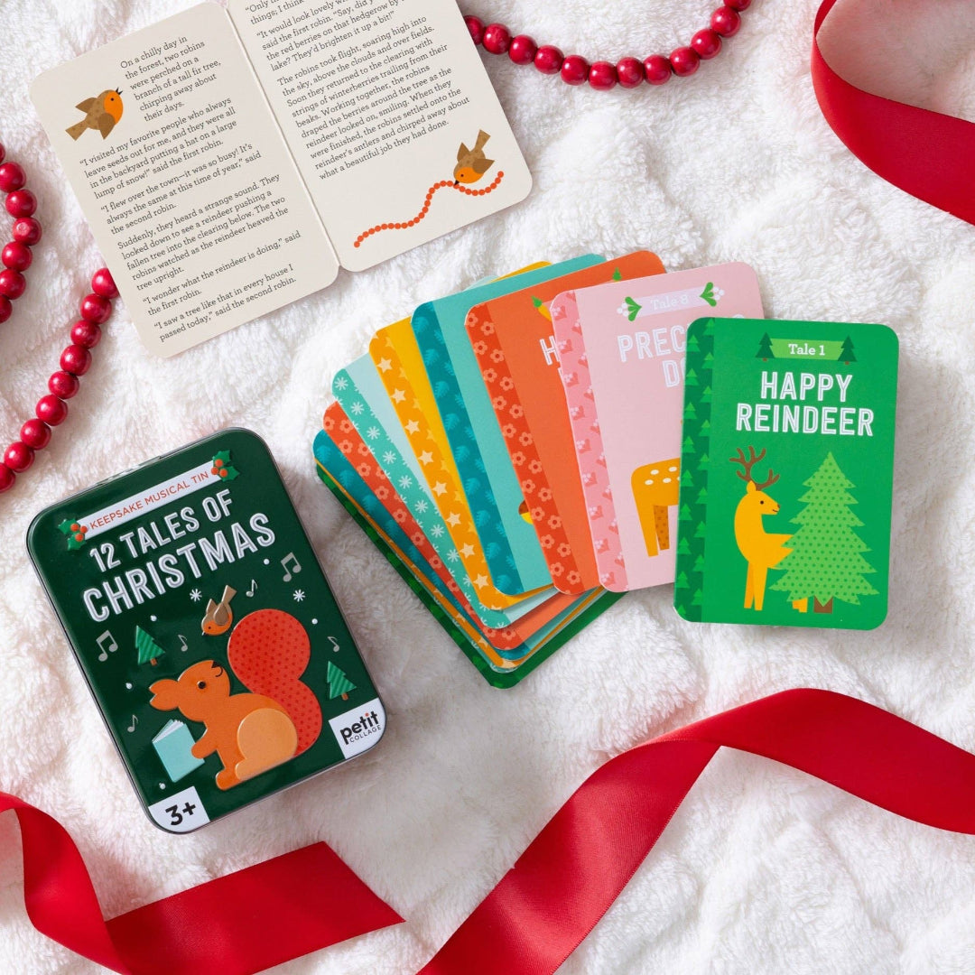 Set of Christmas-themed cards on a white surface with red ribbons.