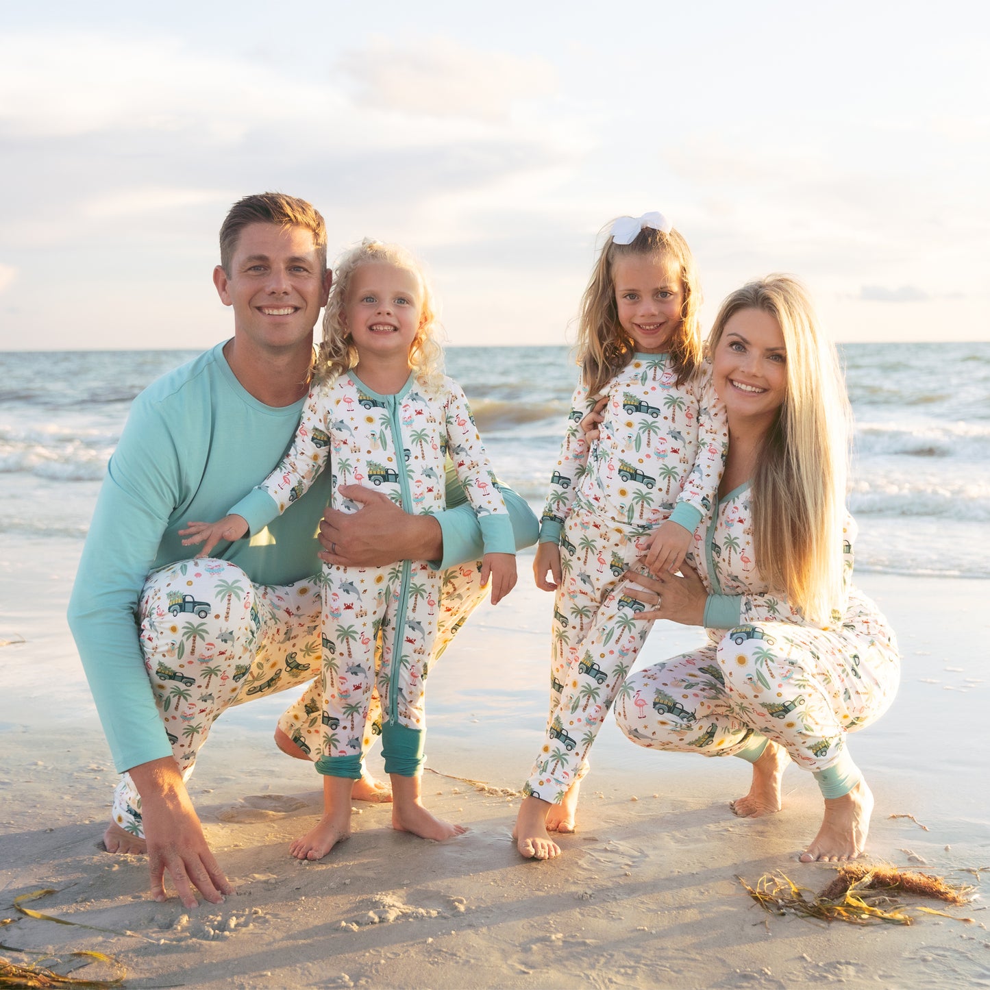Family of four in matching pajamas on a beach