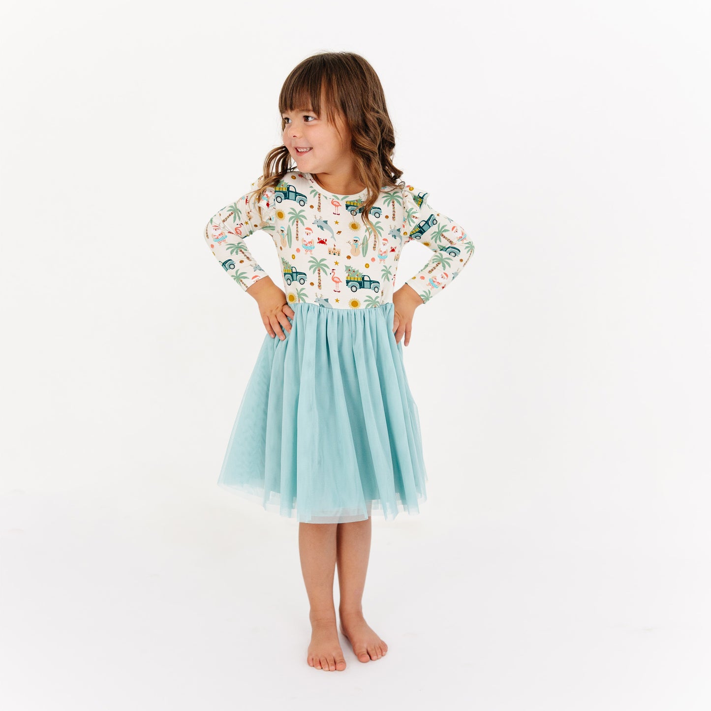 Young girl wearing a patterned top and light blue skirt on a white background