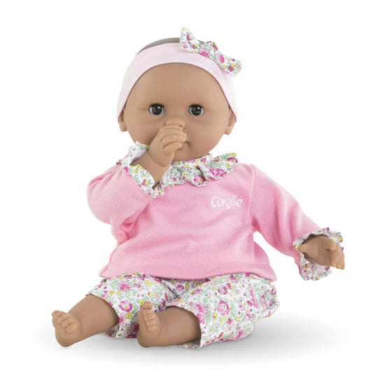 12 inch baby doll wearing a pink and floral outfit