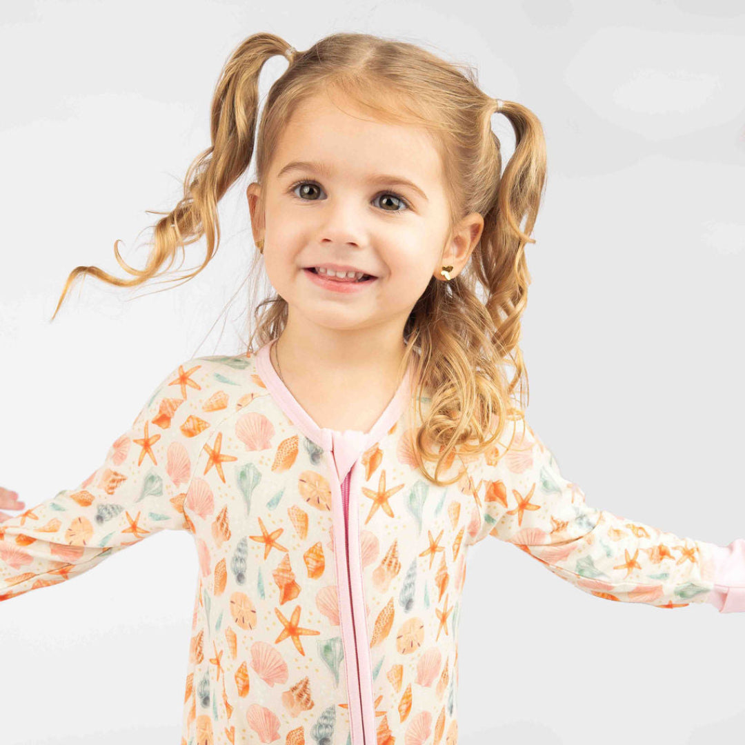Baby girl wearing the Sandy Seashell convertible bamboo pajama.