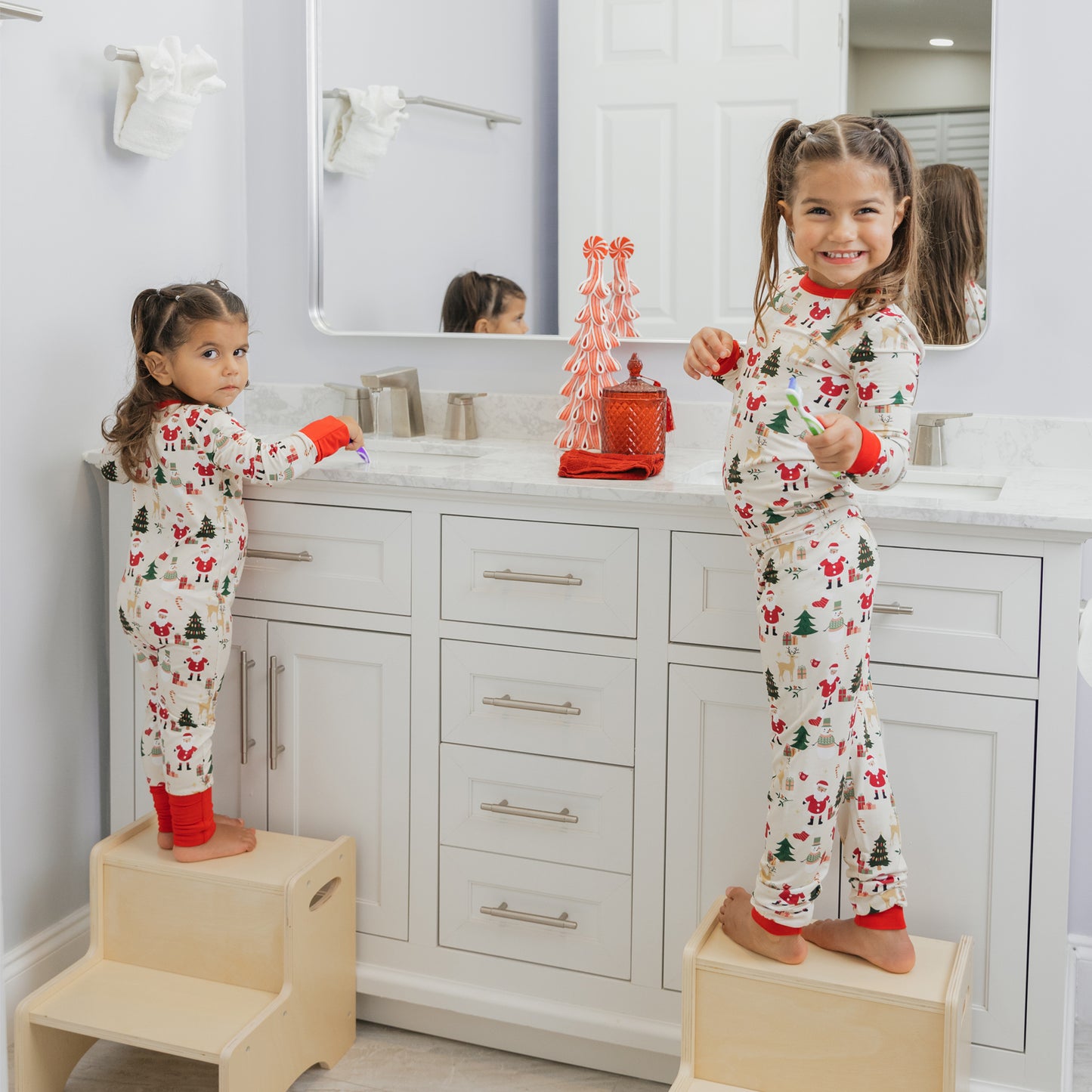 Two kids wearing Cozy Christmas bamboo pajamas stand by the sink, adding holiday cheer to their morning routine.