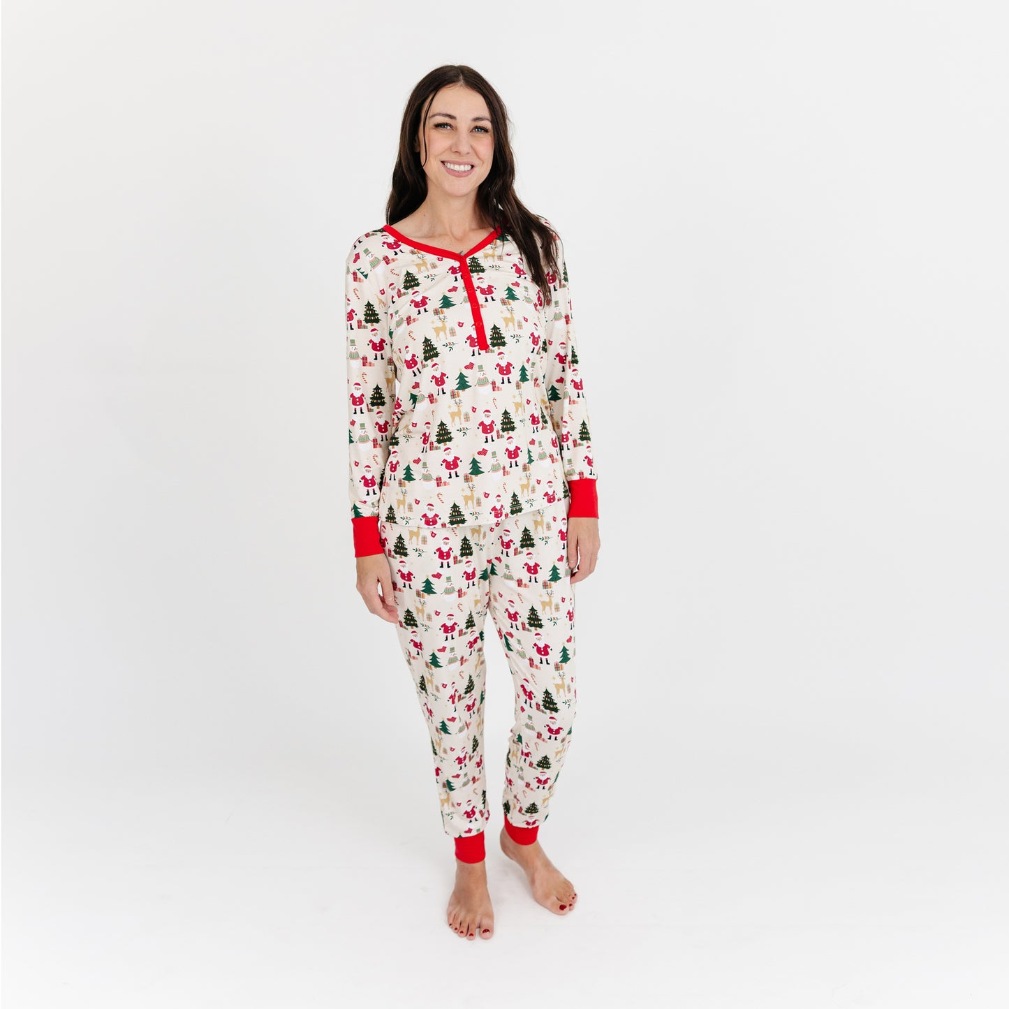 Woman models Cozy Christmas bamboo jogger pajama pants with red cuffs, showcasing buttery soft fabric and festive print.
