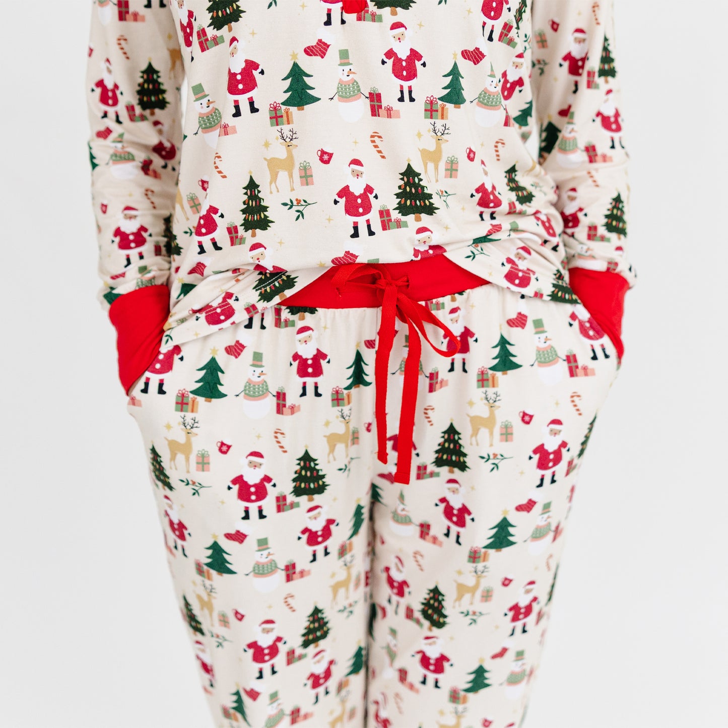 Woman models Cozy Christmas bamboo jogger pajama pants with red cuffs, showcasing buttery soft fabric and festive print.