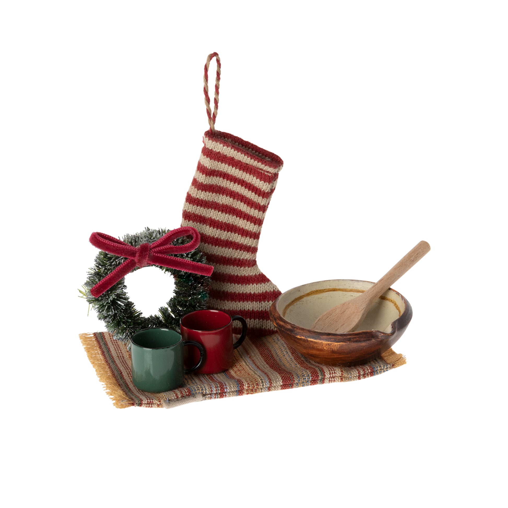 Decorative set with a striped stocking, wreath, mugs, bowl, and spoon on a white background