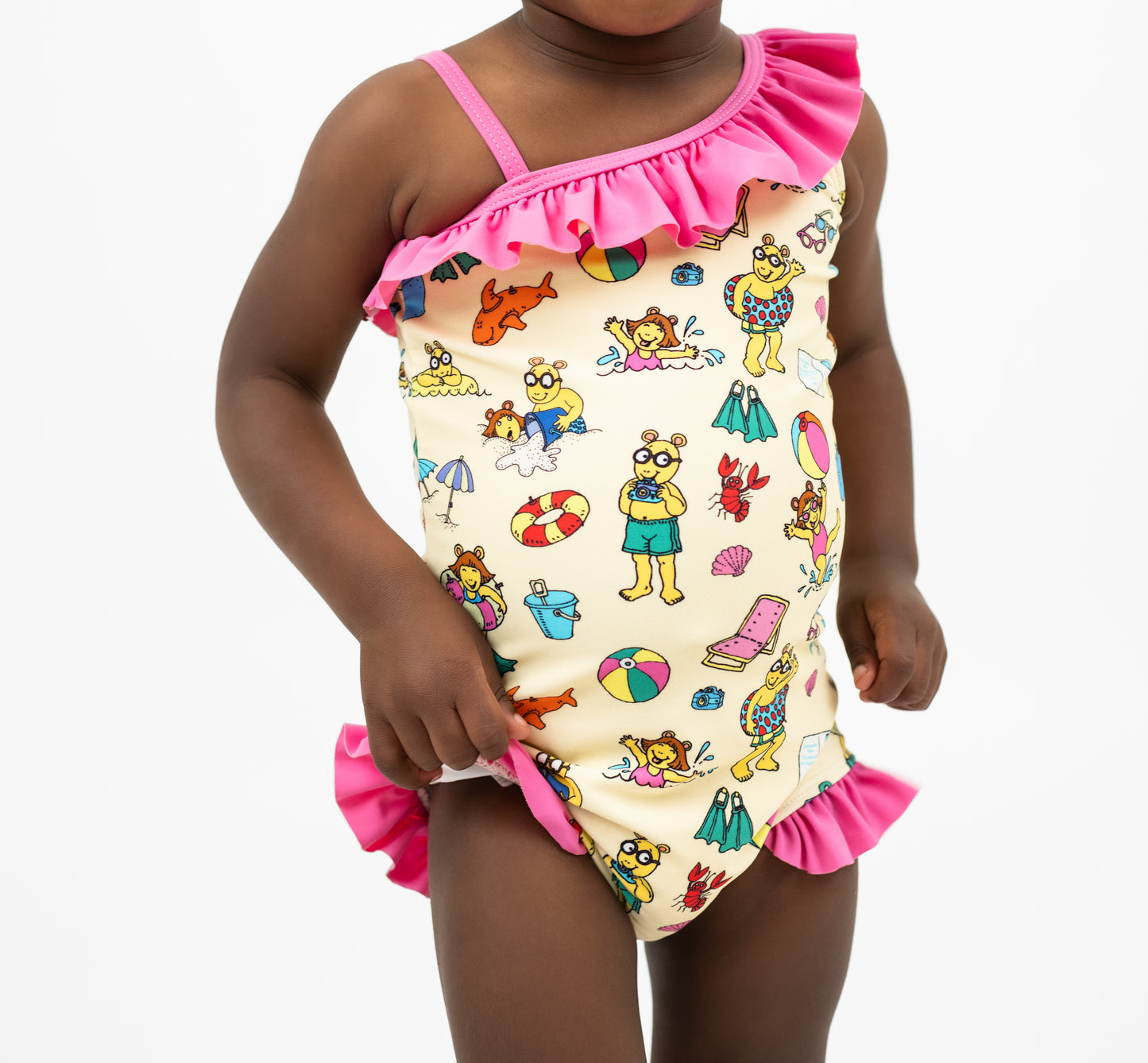 Close up of our Emerson and Friends Arthur's Family Vacation Girls One-Piece Swimsuit, featuring a playful beach-themed print with Arthur and friends, ruffle details on the shoulder and legs, and a soft, stretchy fabric for a fun and comfortable swimwear option.