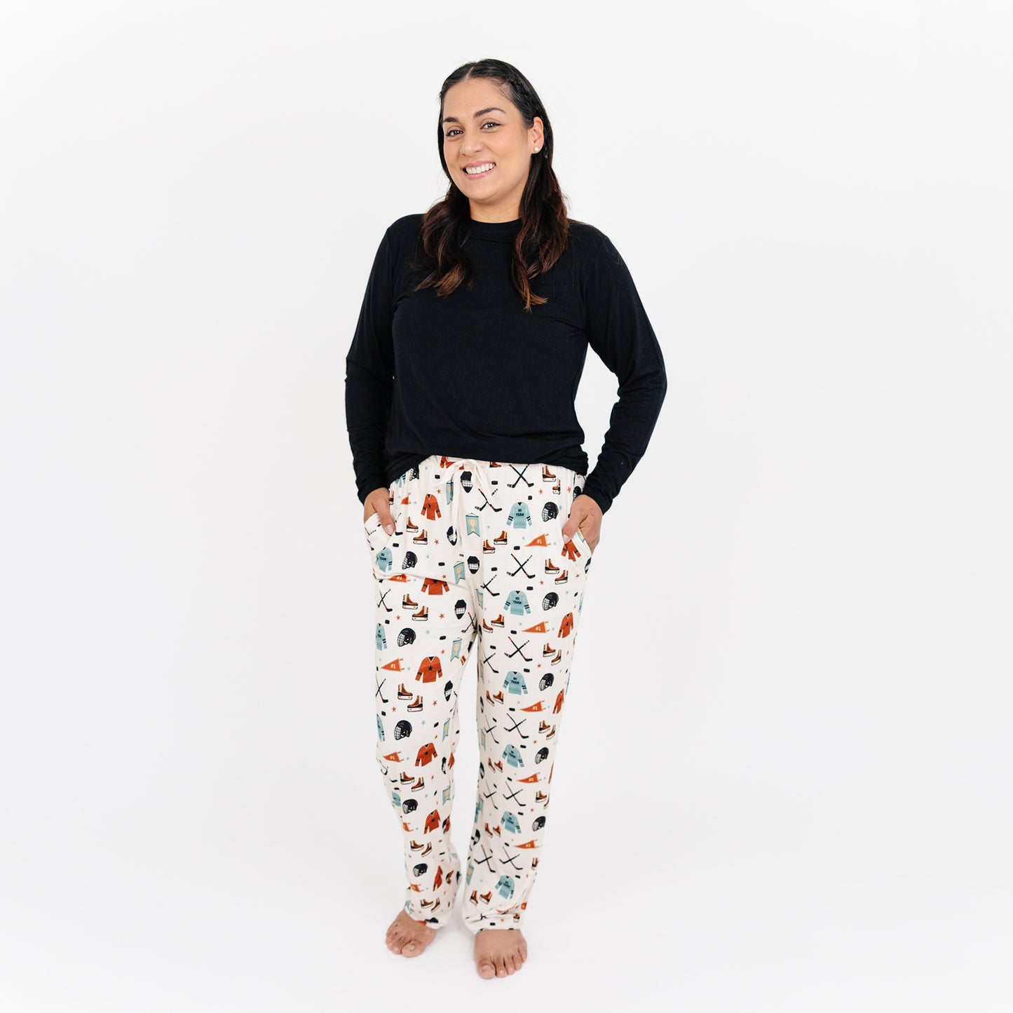 Woman wearing Emerson and Friends Hat Trick bamboo lounge pants with hockey print.