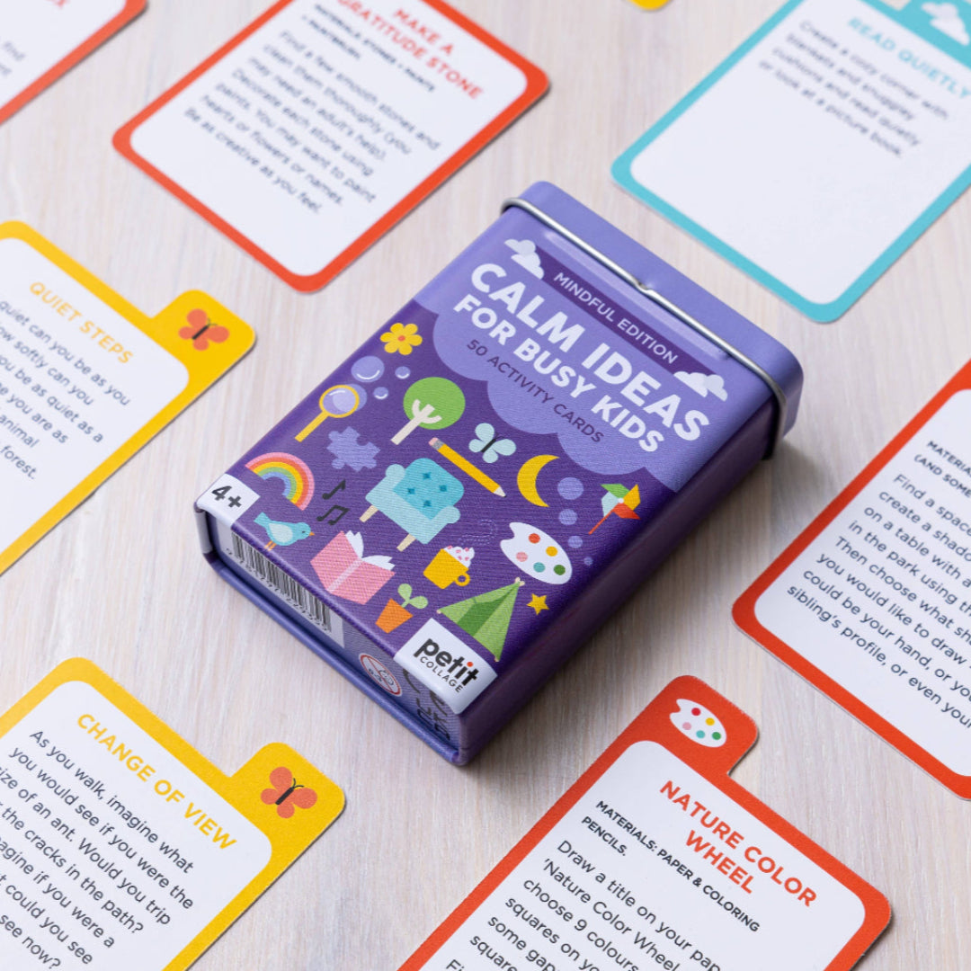 Purple activity card book titled 'Calm Ideas for Busy Kids' by Petit on a wooden surface with colorful cards around.