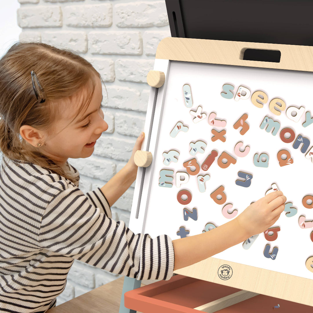 little girl playing with magnetic alphabet letters in different colors