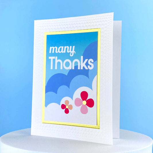 Greeting card that says many thanks and has clouds and flowers on it