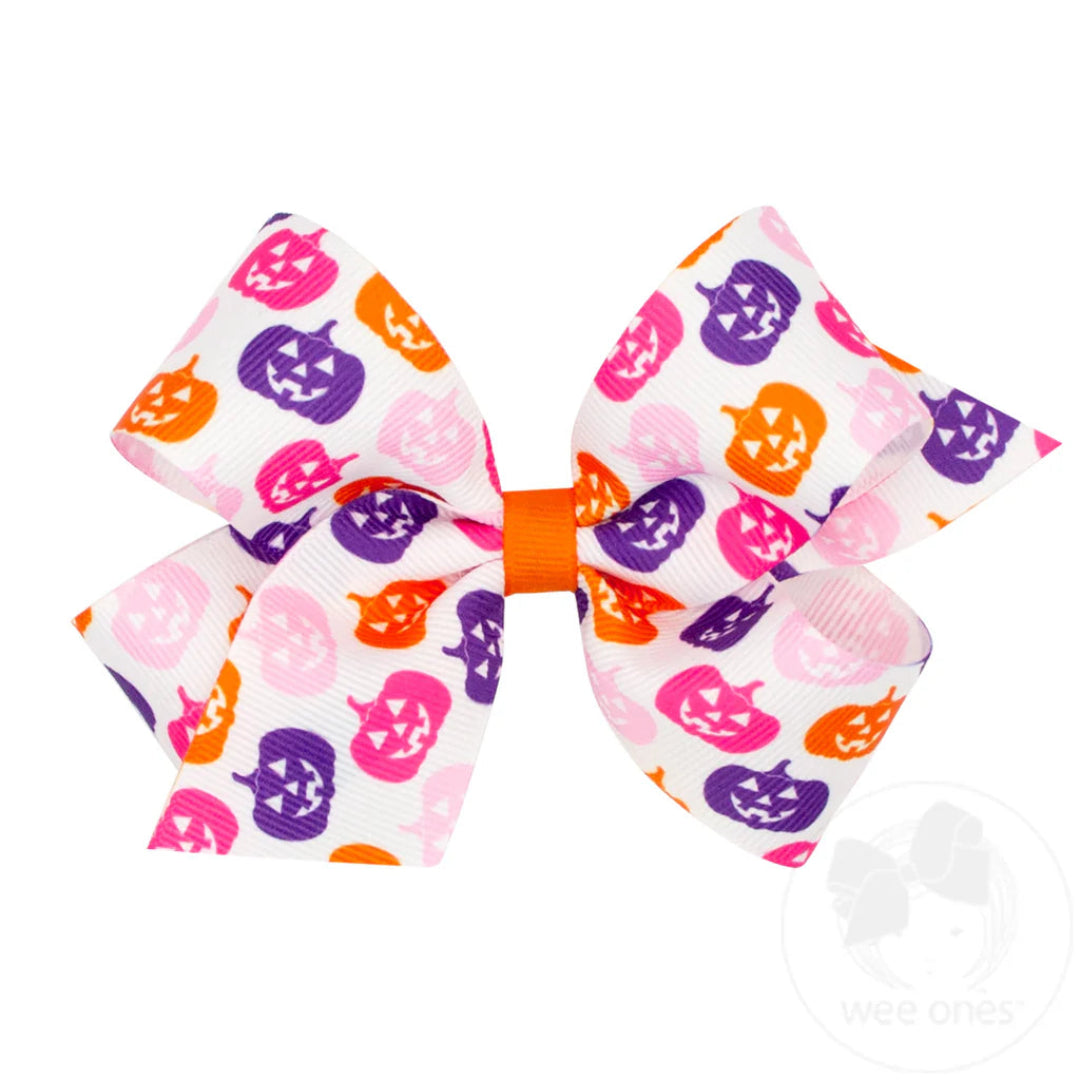 white halloween themed hair bow with pink, purple, and orange pumpkins on it