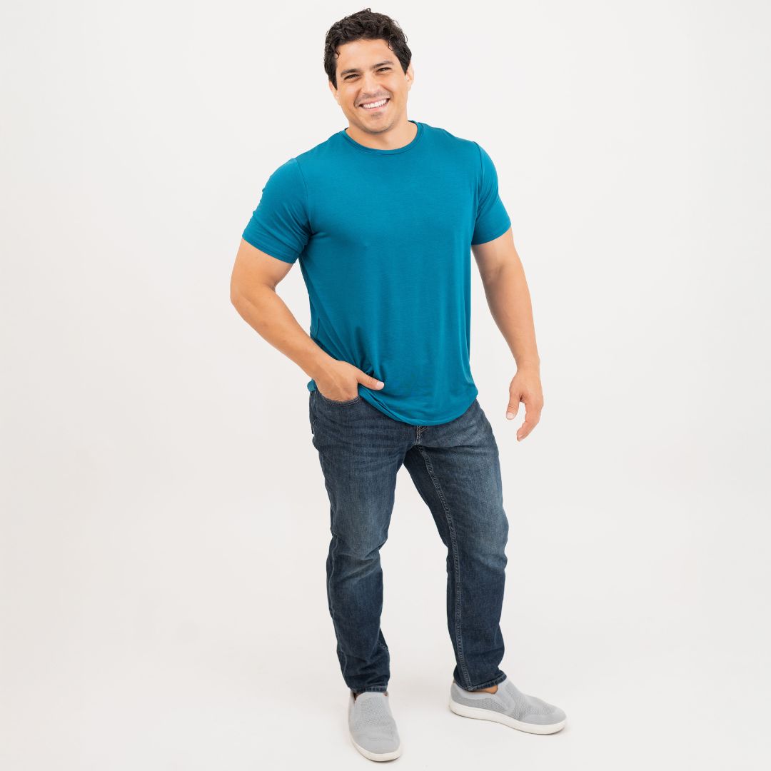 Man wearing a blue bamboo t-shirt and blue jeans on a white background