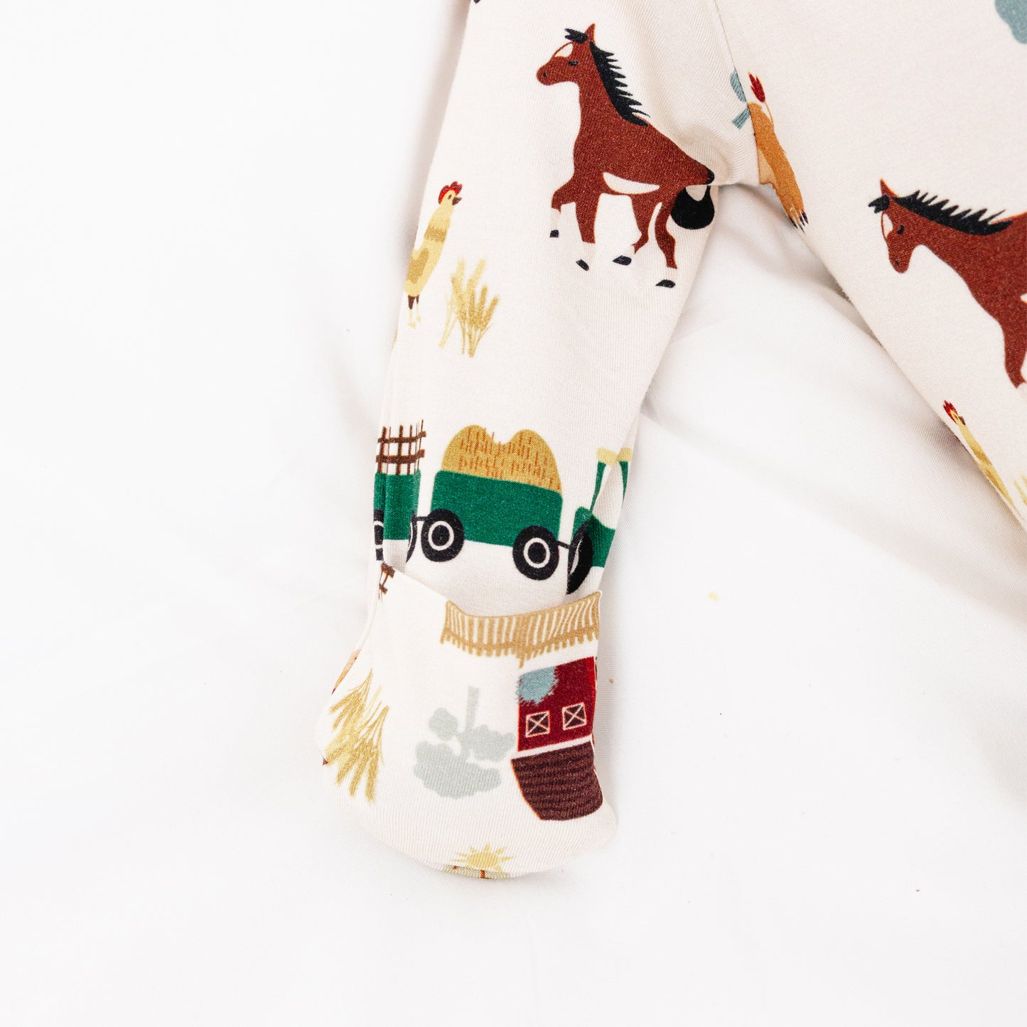 On the Farm bamboo baby gown fabric detail showing farm print with horses, tractors, and cows, hypoallergenic and safe for sensitive skin.
