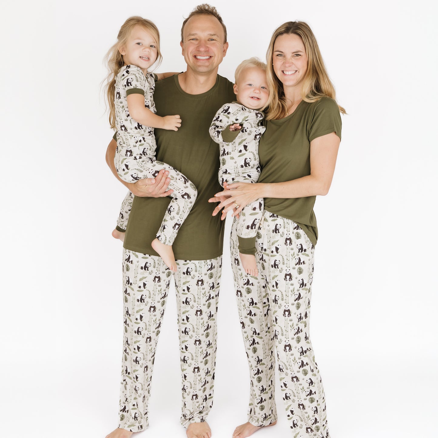 Family of four wearing matching pajamas with a white background