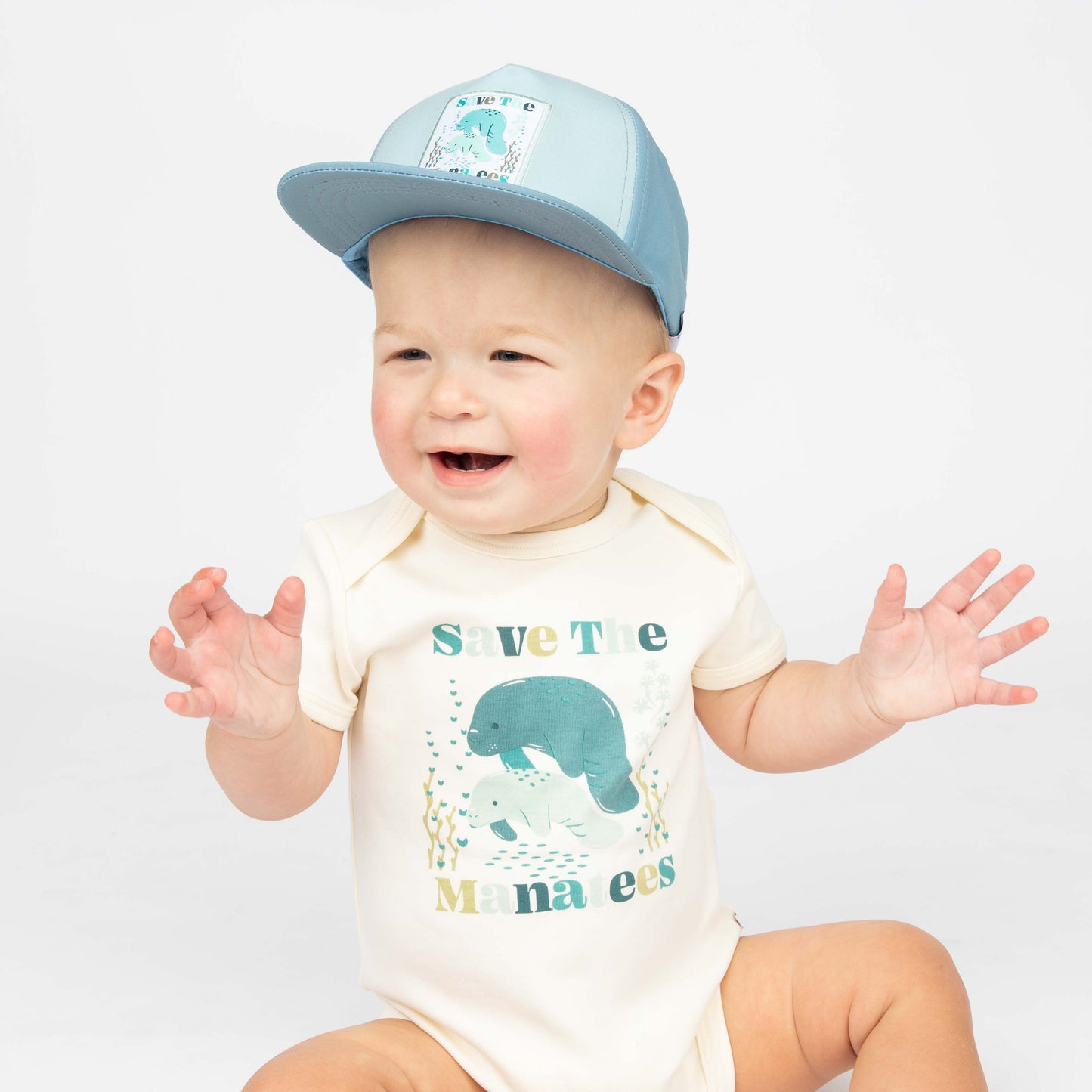 Baby wearing our Save the Manatees Cotton Onesie and Save the Manatees Snap Back.