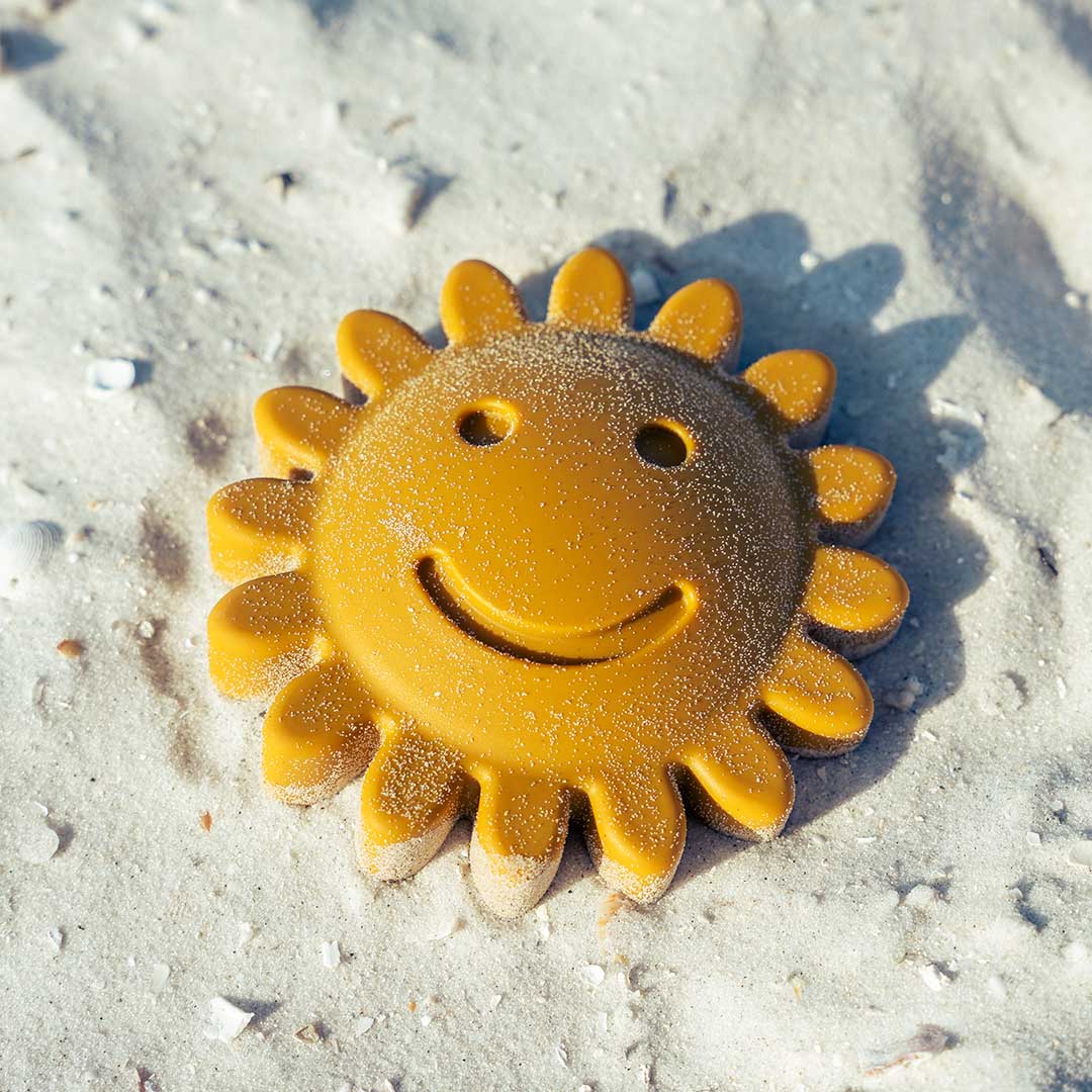 the silicone yellow sun lays sandy in the sand.
