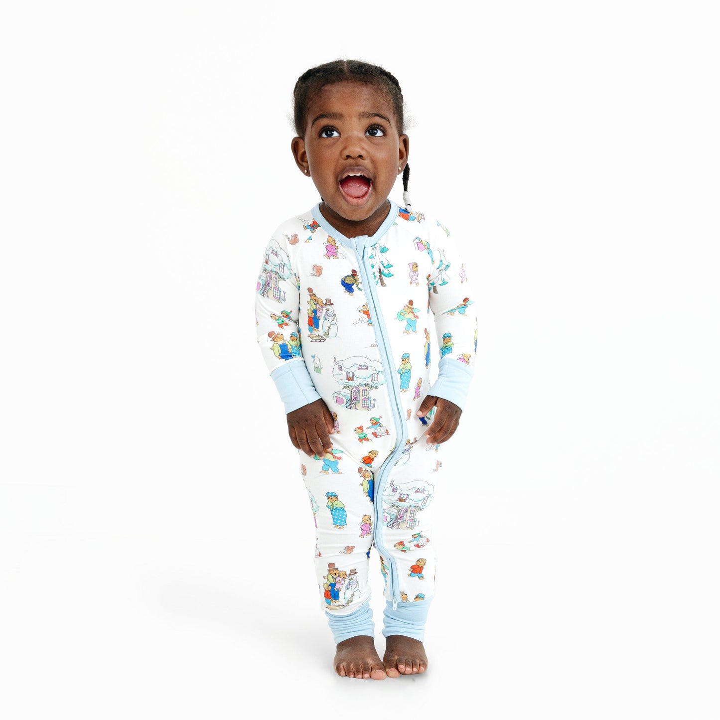 Child wearing a colorful onesie with cartoon characters on a white background