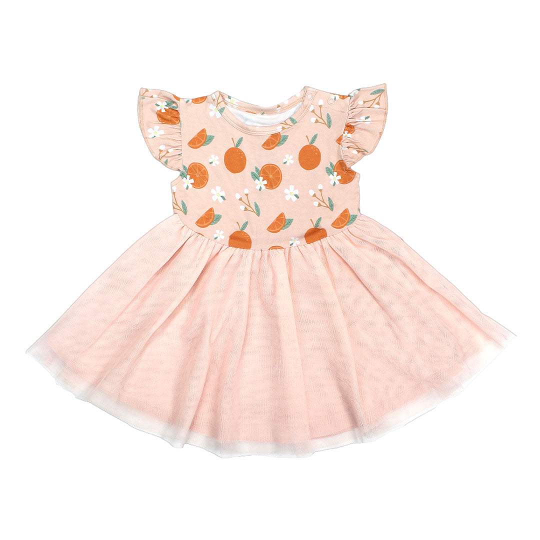 the "freshly squeezed" twirl dress. this dress has the "freshly squeezed" print on the top half and a pink skirt as the bottom half. the "freshly squeezed" print has an assortment of full and half cut oranges scattered around. there is also flower heads and flower stems that intermingle within the print. this is all space out around a pink background space.