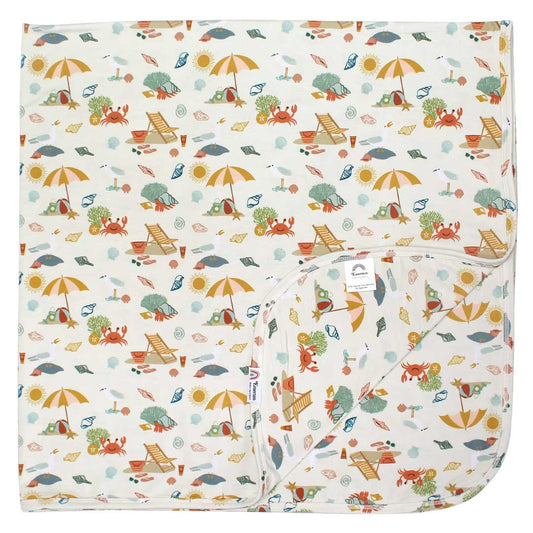 the "beach days" bamboo blanket. the "beach days" print is a scattered print of beach umbrellas, beach balls, sand buckets and shovels, coral, shells, beach chairs, seagulls, flipflops, and sunglass mixed in a orderly and creative way.