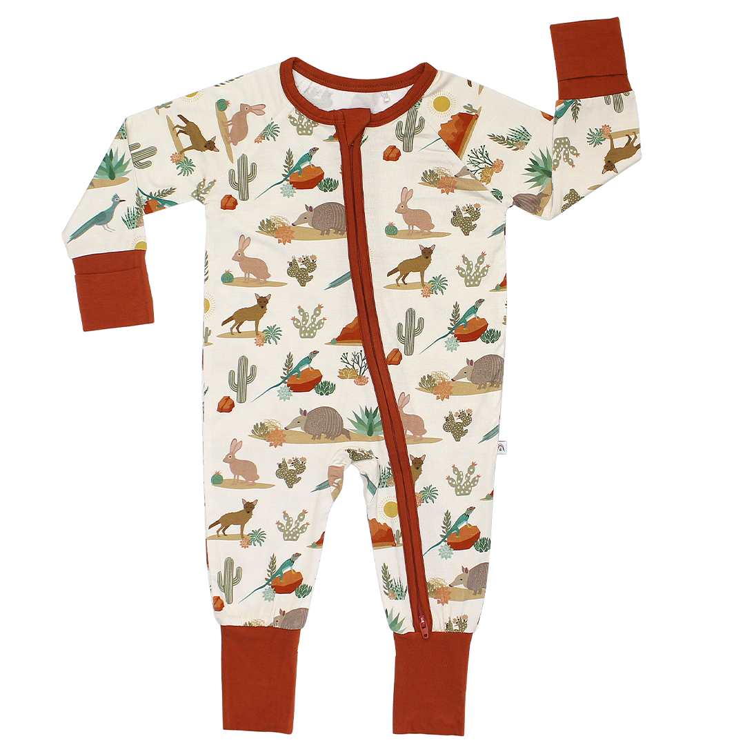 the "desert friends" convertible. the "desert friends" print is a scattered pattern of armadillo, cacti, other desert plants, rocks, desert foxes, lizards, and desert birds. this is all on a beige background.