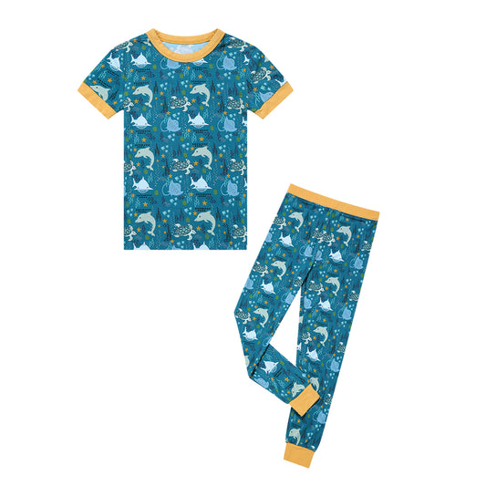 the "ocean friends" matching 2-piece set. the "ocean friends" print is a combination of dolphins, stingrays, fish, starfish, coral, bubbles, and sharks, all spread out on a deep sea blue background.