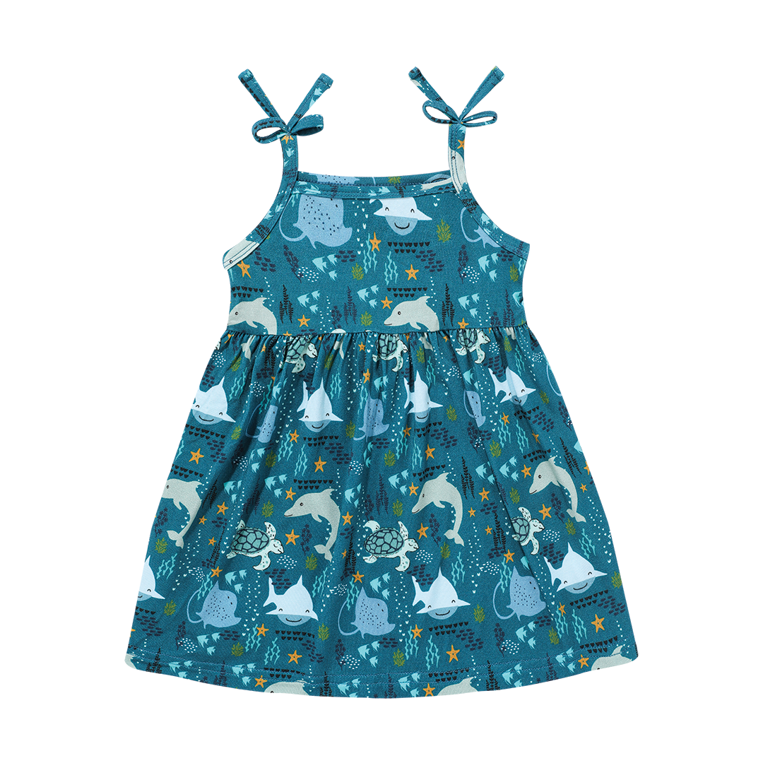 the "ocean friends" bamboo sundress. the "ocean friends" print is a combination of dolphins, stingrays, fish, starfish, coral, bubbles, and sharks, all spread out on a deep sea blue background.
