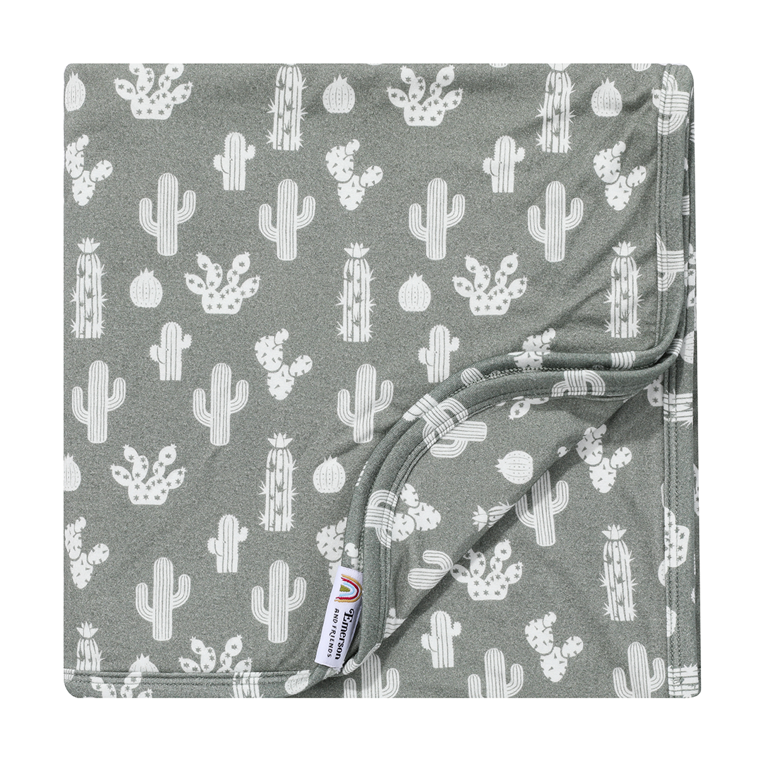 the "stay sharp" bamboo blanket. the "stay sharp" print is a variety of different white cacti on a greyish/green background.