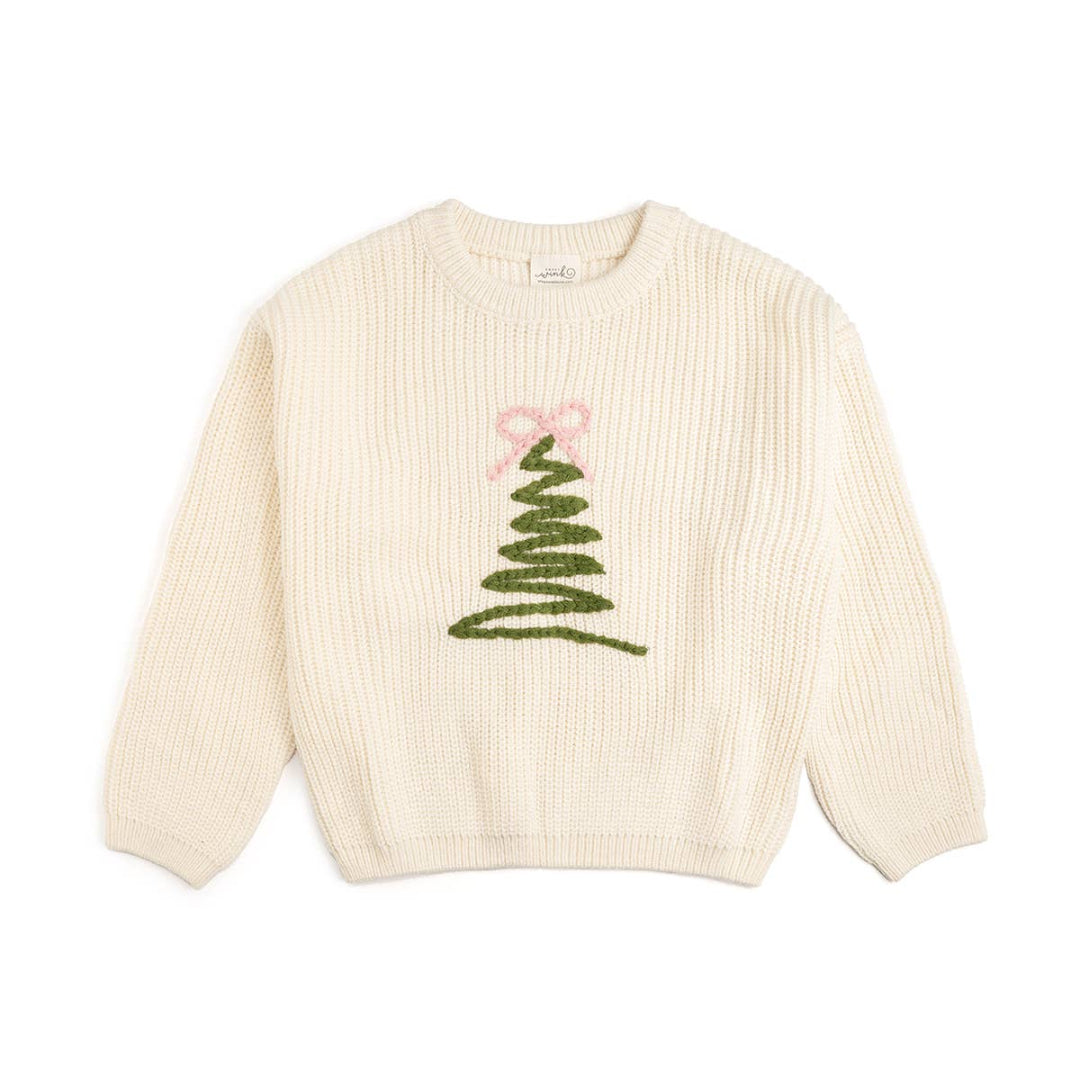 cream colored knit oversize sweating with a green embroidered christmas tree shaped zigzag in the middle of the sweater and a pink embroidered bow on the top of the christmas tree