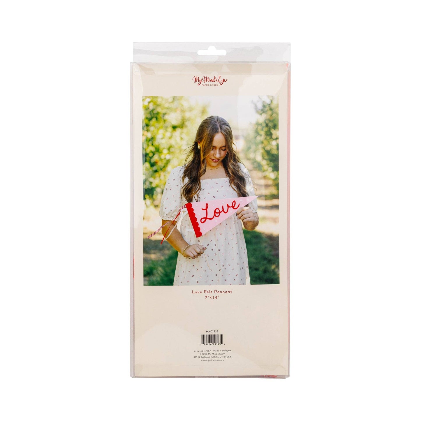 Package of a pink baby blanket with 'Love' text held by a woman outdoors.