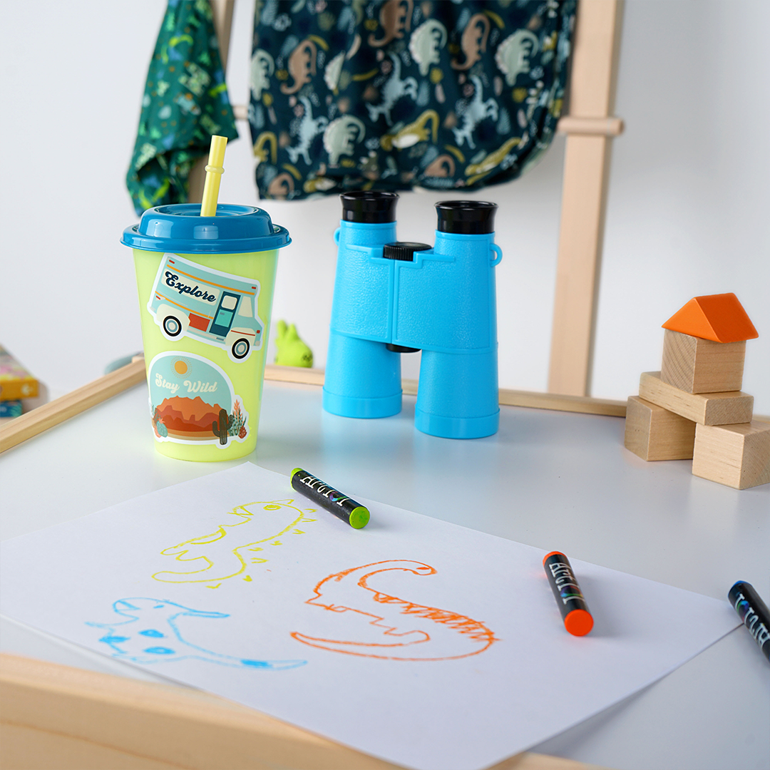 a childrens cup has the "explore camper van" sticker. a blue and white van with orange tones. the word "explore" is printed on the window.