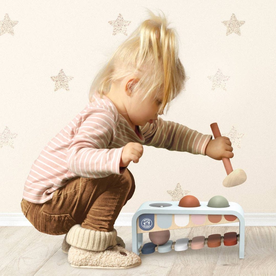 little girl playing with multi colored xylo bench musical toy